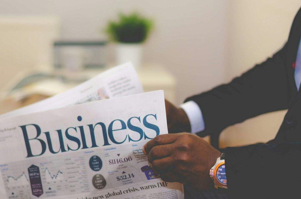 A hand of business consultant reading a news paper strategizing on building a REIT in Indonesia.